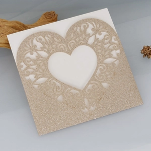 Detail of laser-cut glitter paper heart card with champagne gold floral vine patterns