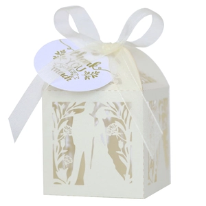 Détail de la boîte à bonbons blanche ajourée avec ruban et étiquette dorée Merci