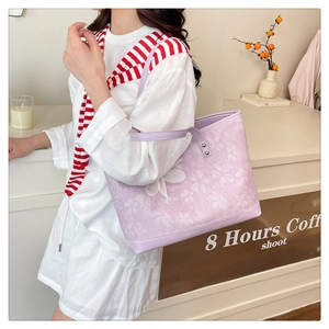 Detail view of purple floral embossed tote bag with white flower charm and soft PU texture