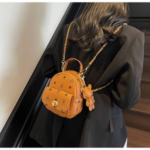 Detail eines braunen Mini-Rucksacks aus PU-Leder mit Bärenmuster und Metallkettenriemen