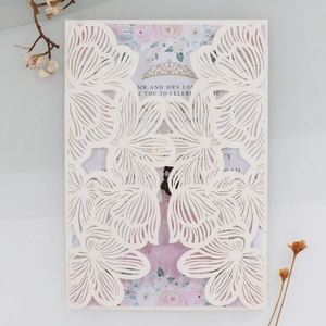 Detail of laser-cut white rose invitation with floral inner card and golden crown
