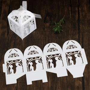 Detailed laser-cut white wedding favor box featuring bride and groom silhouette with ribbon