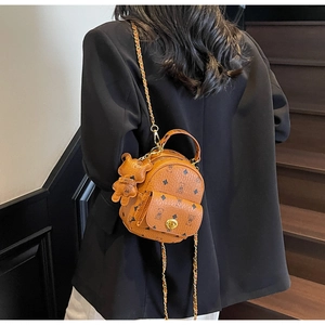 Rückansicht eines Models mit braunem Mini-Lederrucksack, Bärendruck und Kettenriemen