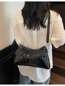 Minimalist black patent leather shoulder bag with silver studs and heart pendant charm