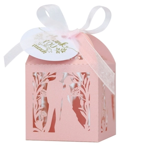 Détail d'une boîte à dragées rose découpée au laser avec ruban et étiquette merci