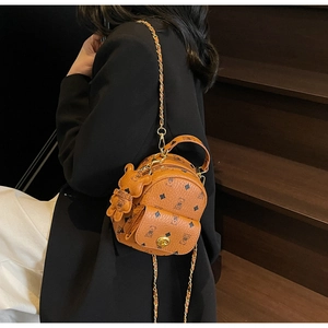 Detailansicht Mini-Rucksack aus braunem Leder mit goldener Kette und Bären-Anhänger