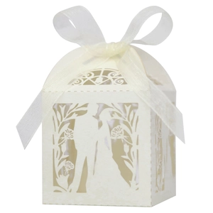 Detail of laser-cut wedding favor box with bride and groom silhouette and white ribbon
