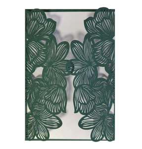 Close-up of laser-cut dark green floral invitation cover with delicate rose patterns