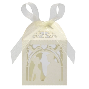 Detail of laser-cut ivory wedding favor box featuring romantic couple silhouette and bow