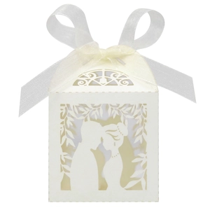 Detail of laser-cut white wedding favor box featuring romantic couple silhouette design