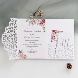 Detailed view of laser-cut wedding invitation set with floral patterns and RSVP card