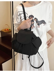 Minimalist black canvas bucket backpack for women featuring a drawstring and flap closure