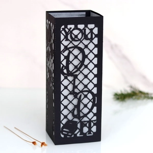 Macro shot of black laser-cut graduation lantern with You Did It text and cap pattern