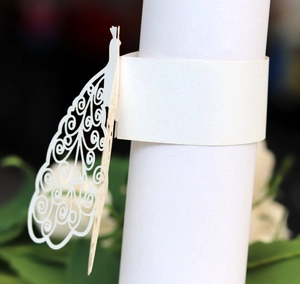 Macro detail of laser-cut peacock paper napkin ring with elegant hollowed pattern
