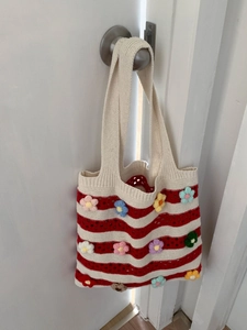 Striped crochet tote bag with handmade 3D floral accents for beach vacations