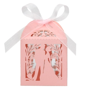 Detailed laser-cut pattern of bride and groom silhouette on pink wedding favor box