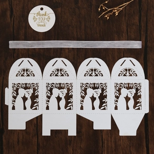 Mise à plat de la boîte cadeau blanche découpée au laser avec ruban argenté sur bois