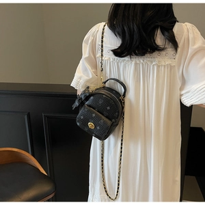 Schwarzer Mini-Rucksack mit Monogramm-Muster und Kettenriemen in der Seitenansicht