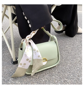 Détail du sac selle vert menthe avec foulard en soie à cerises et boucle en métal doré