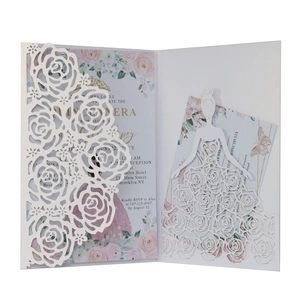 Macro view of white laser-cut floral invitation set with pink rose inner card