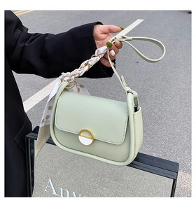 Détail du sac selle vert menthe avec poignée en foulard de soie et boucle magnétique