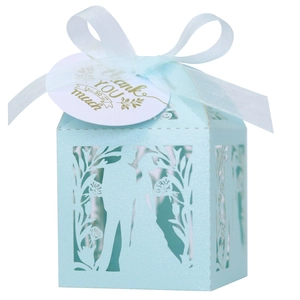 Détail de la boîte à dragées bleu clair avec silhouette découpée au laser et ruban blanc