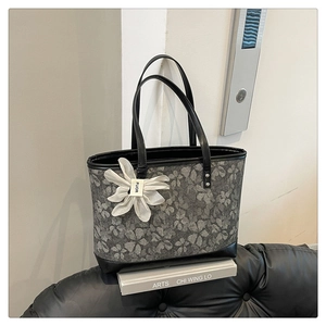 Detail of vintage jacquard tote bag featuring floral embroidery and leather trim
