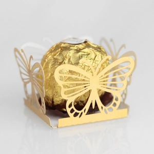 Macro shot of gold laser-cut butterfly chocolate box showing intricate hollow details