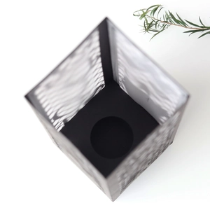 Macro view of laser-cut geometric patterns on black metal lanterns for graduation parties