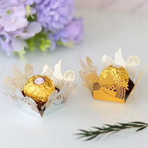 Laser-cut paper candy holder with intricate angel wings and champagne pearl finish