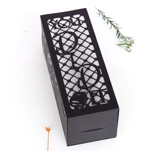 Detail of laser-cut black paper gift box with For You hollow design and geometric pattern