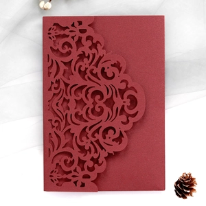 Detail of burgundy laser-cut invitation card with floral patterns and pearlescent finish