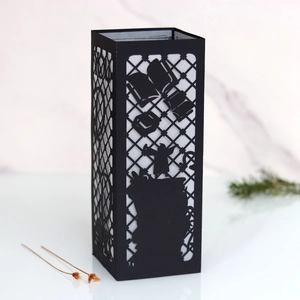 Detail of black laser-cut graduation lantern with wizard silhouette and hat patterns