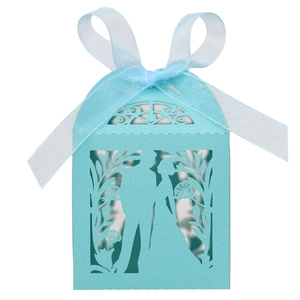 Detail of light blue laser-cut wedding favor box with ribbon and bride groom design
