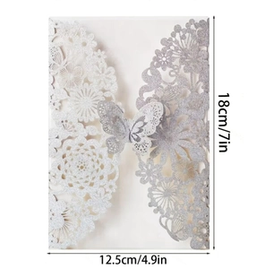 Detailed laser-cut silver glitter invitation featuring intricate floral and butterfly designs