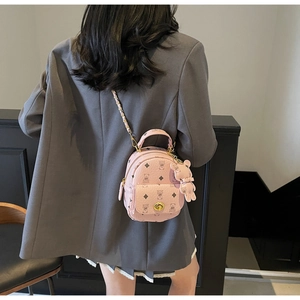 Detailansicht eines rosa Mini-Rucksacks mit Bärenmuster und Metallkette am Modell