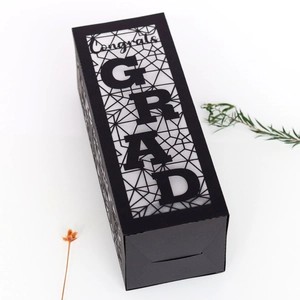 Detail of matte black graduation paper lantern featuring hollowed Congrats GRAD text