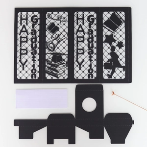 Flat lay of laser-cut black paper lantern panels featuring graduation motifs and motifs
