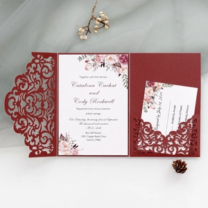 Macro view of burgundy laser cut wedding invitation with floral insert card