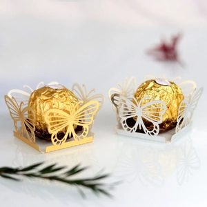 Macro shot of laser-cut butterfly hollow chocolate wrappers in gold and white finishes