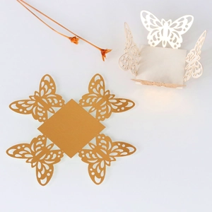 Laser-cut hollow butterfly wedding favor box in gold and pearl white pearlescent paper