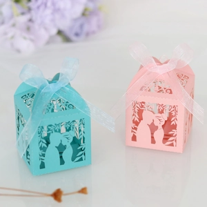 Detailed laser-cut candy boxes in blue and pink with elegant ribbon bows for weddings