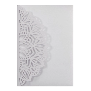 Detailed macro view of laser-cut pearl paper wedding invitation sleeve with mandala pattern