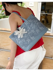 Blue floral jacquard tote bag with leather straps and flower charm on shoulder
