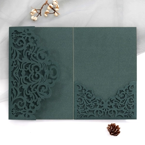 Detail of dark green laser-cut wedding invitation with elegant European vine patterns
