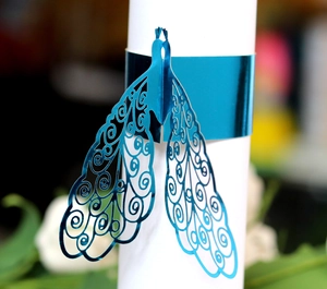 Macro detail of royal blue laser-cut peacock napkin ring with intricate hollow patterns