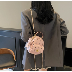 Details zum rosa Mini-Rucksack mit Bärenmuster und Metallkettenriemen am Modell