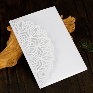 Detailed laser-cut white wedding invitation with elegant semi-circle mandala pattern