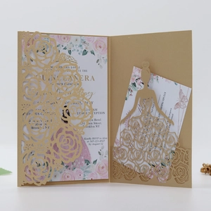 Detail of laser-cut gold rose invitation featuring a dress silhouette and floral insert