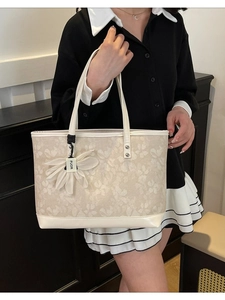 Cream embroidered tote bag with floral patterns and leather handles for casual commuting